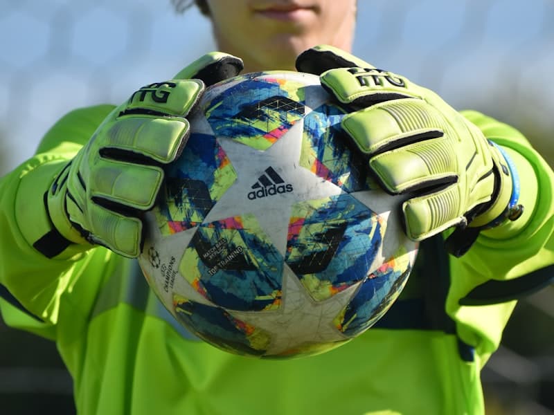 Goalkeeper holding the ball with gloves